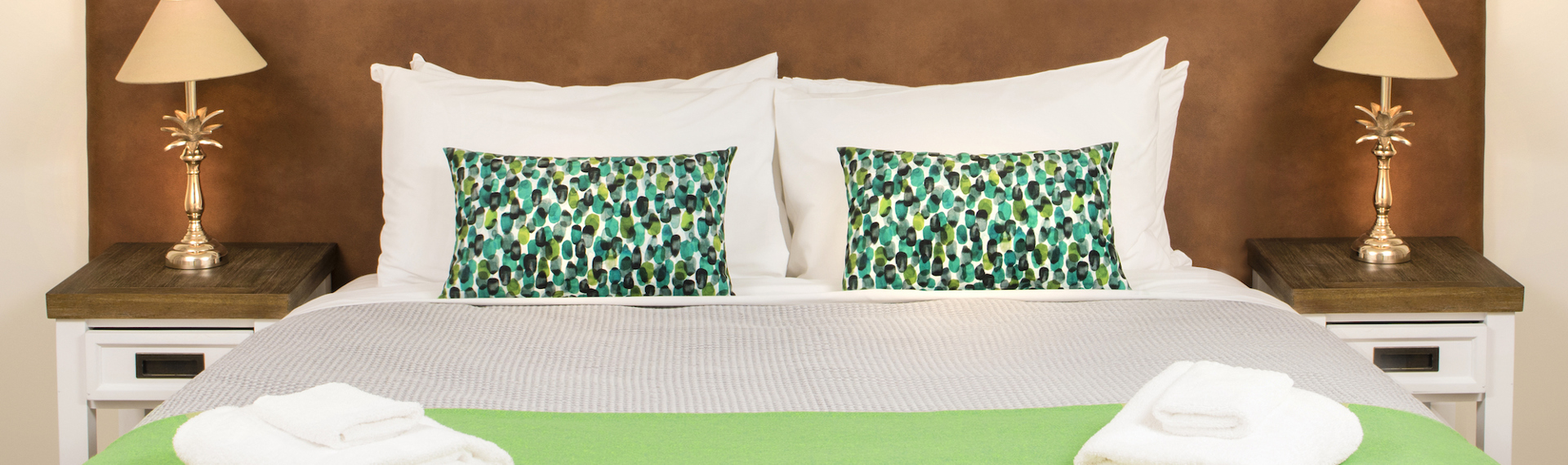 A king bed in an Endeavour Suite decorated with nature-inspired details at Furneaux Lodge in the Marlborough Sounds, New Zealand.