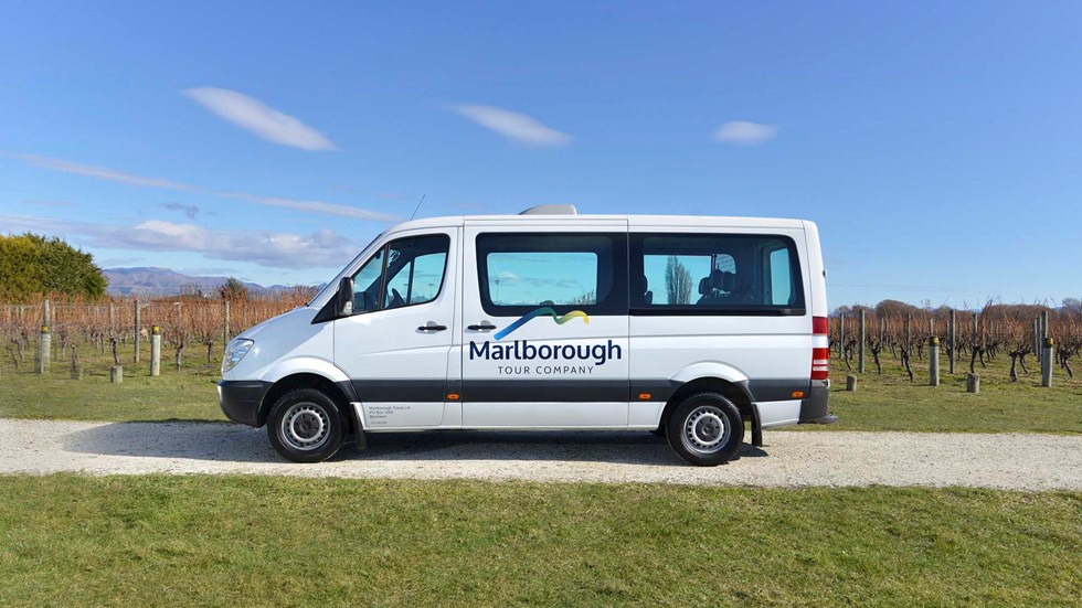 Close up of white van parked in vineyard on a Marlborough Tour Company wine tour, near Blenheim in Marlborough at the top of New Zealand's South Island.