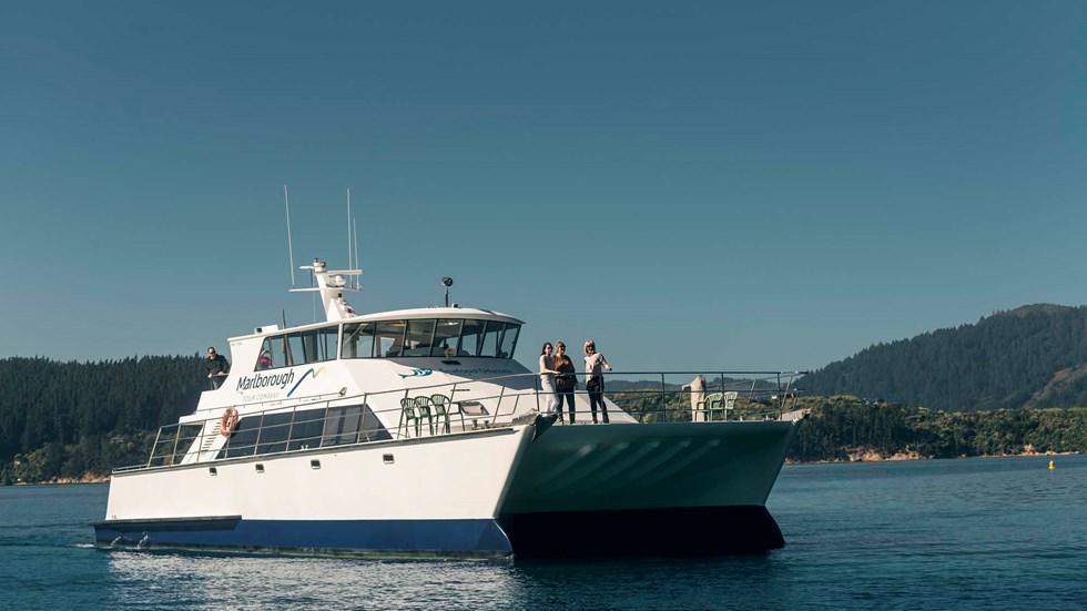 Close up of MV Odyssea with people on the bow cruising the Marlborough Sounds, at the top of New Zealand's South Island