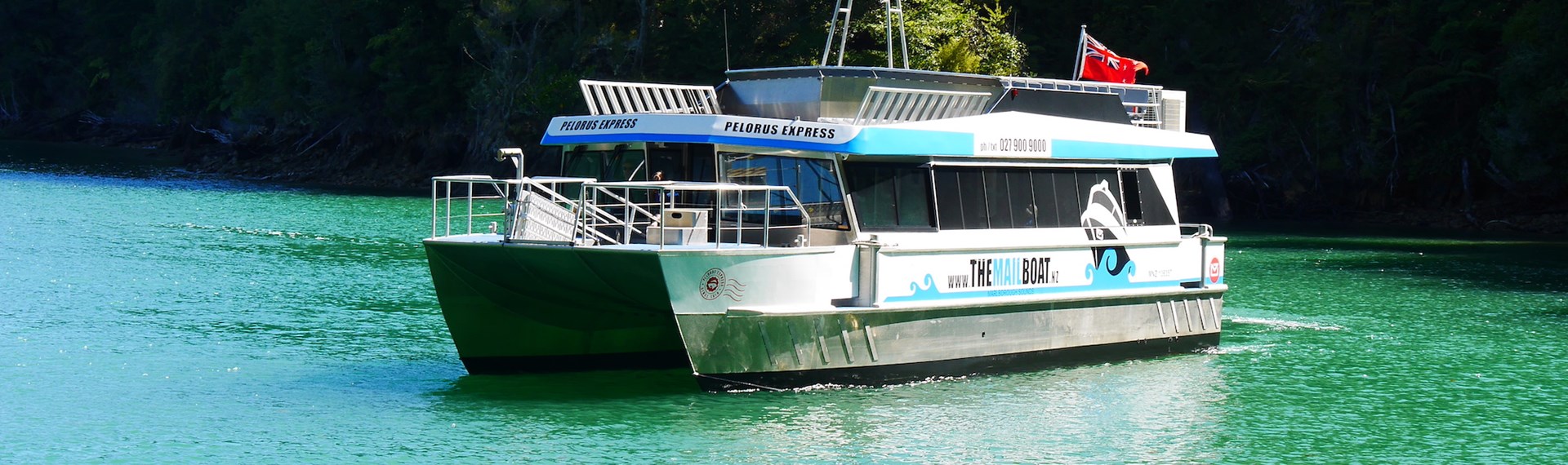 Our Pelorus Mail Run Cruise in the beautiful blue/green waters of the Pelorus Sound/Te Hoiere with a bush backdrop.